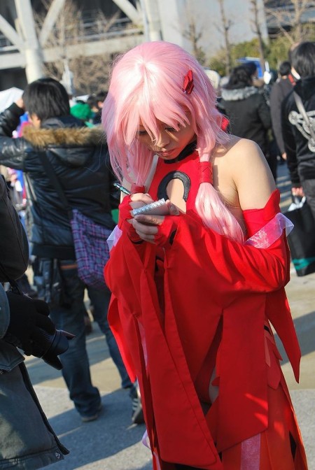 何かをメモるコスプレ娘。胸元が気になる